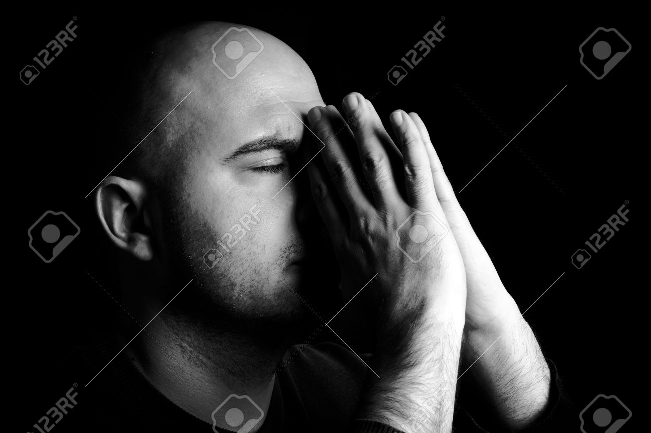 Man alone praying,low key and monochrome