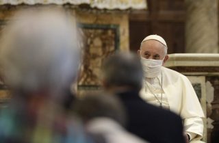 Il papa che indossa una maschera fa appello alla fraternità durante la preghiera interreligiosa